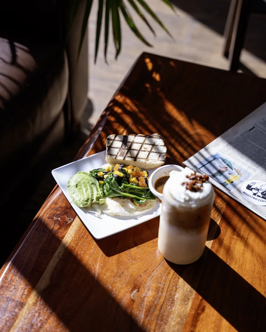 Café sandwich, salad, and iced drink on a sunlit table, photographed by NG Studios